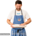 Ein Mann in einer blauen Schürze und dem Lund-Shirt – mit blauem Logo – hält eine abgedeckte runde Auflaufform in der Hand, lächelt und blickt darauf hinunter (Bild mit KI bearbeitet)