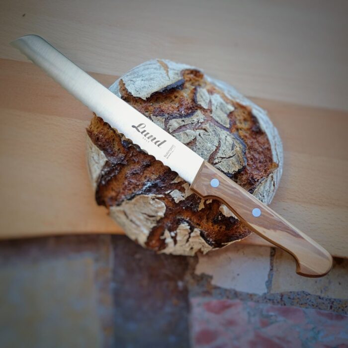 Lund-Brotmesser Ein Lund Brotmesser mit einem Laib Brot darauf.