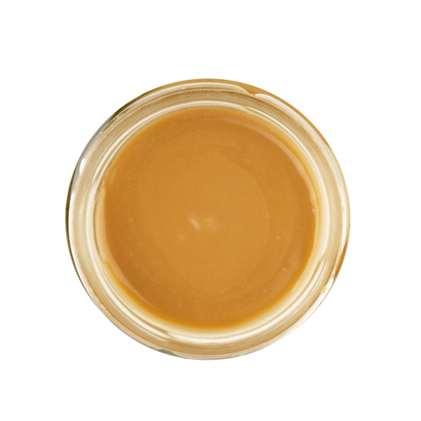 Lund Sylt aufstrich meersalzkaramell-open Draufsicht auf ein Glasgefäß gefüllt mit glatter, cremiger Karamellsauce auf weißem Hintergrund.