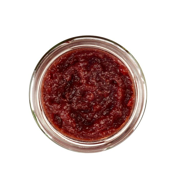 Lund Sylt marmelade Kirsche-op Draufsicht auf ein Glasgefäß gefüllt mit roter Tomatensoße oder -paste vor einem weißen Hintergrund.