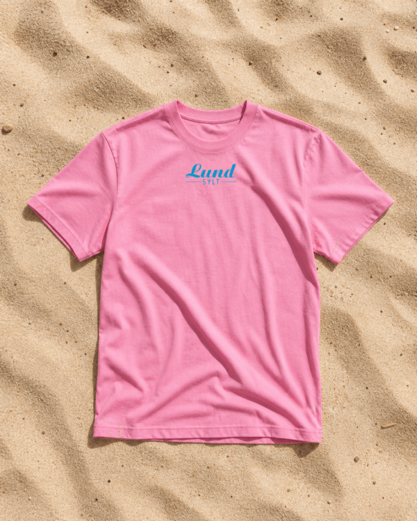 Shirt bubblepink auf sand blaues logo Mock up Pinkfarbenes LundSylt T-Shirt in XXL mit "Lund SYLT" in blauer Schrift auf sandfarbenem Hintergrund.
